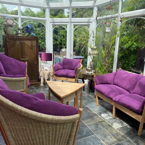 purple cushioned sofa and chair set with tables